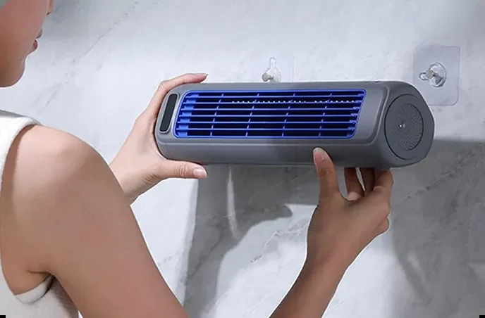 Two hands placing the Vital Cooling Breeze onto a wall mount